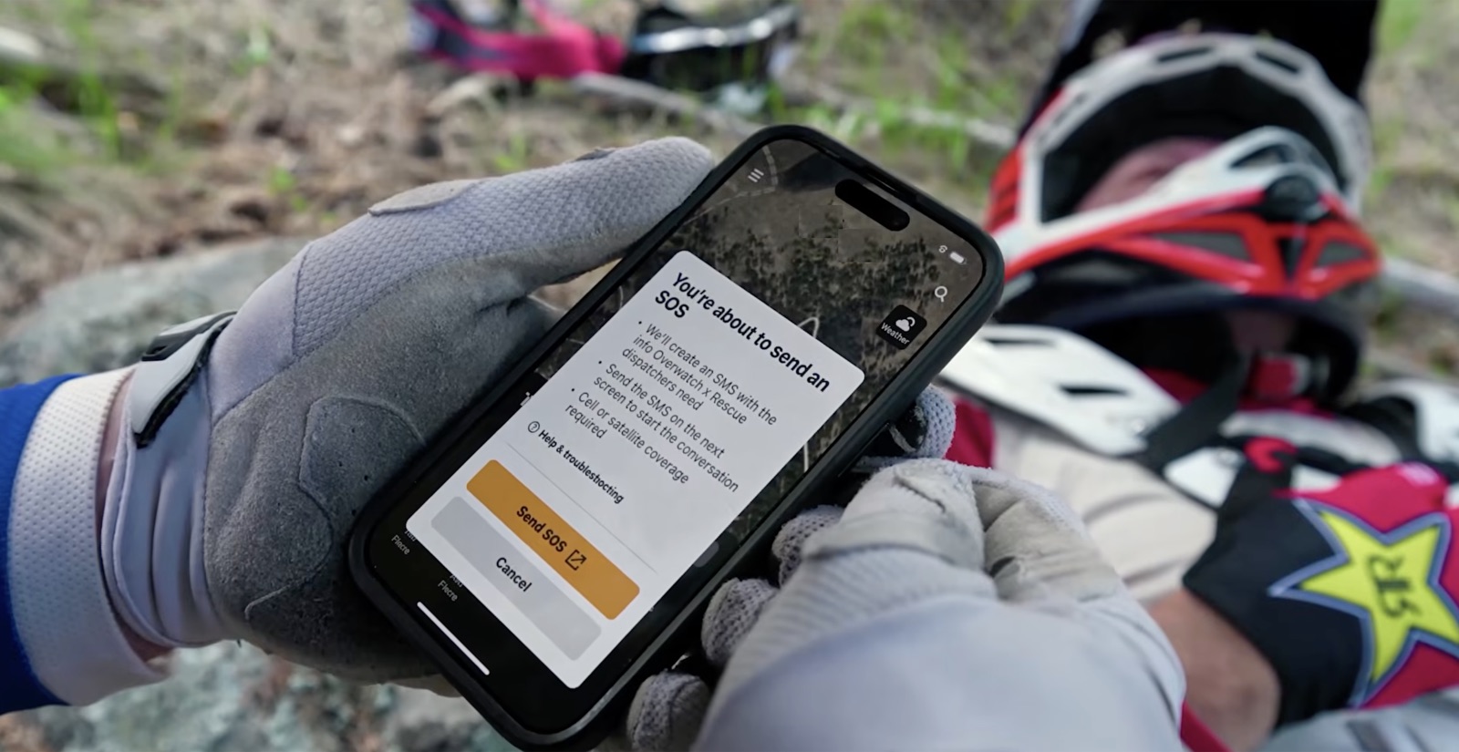 Rider sending an SOS from a remote trail